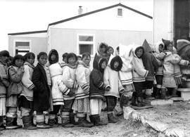 Photograph of children lining up outside of their school