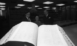 Photograph of three unidentified people in the law library