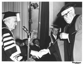 Photograph of two men shaking hands at the opening ceremony of the Sir James Dunn Building