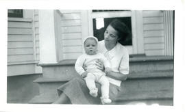 Photograph of Edith Raddall, seated on a staircase, holding her son, Tommy, aged 14 months
