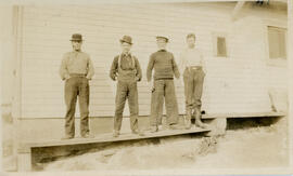 Photograph of four unidentified persons standing outside of Main Station on Sable Island