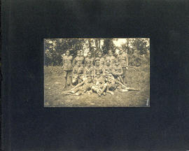 Photograph of a military division in uniform and holding a dog