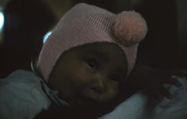 Photograph of a baby with a pink hat