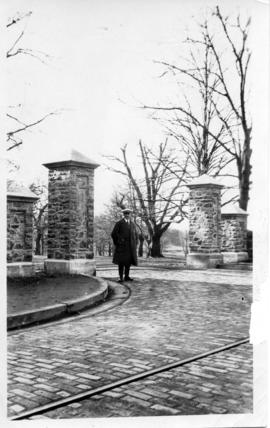 Photograph of a man standing next to the class of 1912 memorial