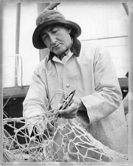 Photograph of Nova Scotian fisherman repairing net