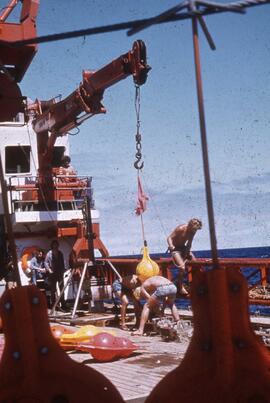 Slide depicting ocean vessel, mining equipment, workers