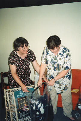 Photograph of Janice Slauenwhite and Kelly Casey looking at baby shower gifts
