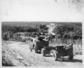 Photograph of a QF 25-pounder howitzer convoy, Leclerc Bridge, near Tracadie, 1943