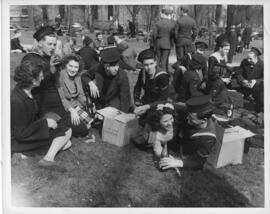 Photograph of servicemen and women celebrating VE-Day with looted Keith's beer in a downtown Hali...