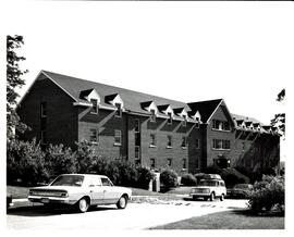 Photograph of the newly constructed Trueman House with landscaping and cars parked out front at t...