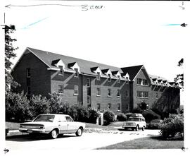 Photograph of Trueman House at the Nova Scotia Agricultural College, with landscaping and cars pa...