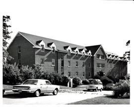 Photograph of the Trueman House at the Nova Scotia Agricultural College, with landscaping and car...