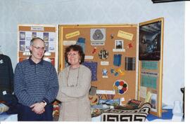 Photograph of two standing people with the Nova Scotia wool board display case