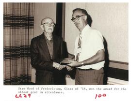 Photograph of Stan Wood receiving an award from another person for winning "oldest grad in attend...