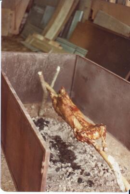 Photograph of what is likely a sheep or lamb being roasted during the field day at Bill Mathewson...