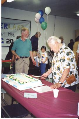 Photograph of Harry Crouse, President, and Edith Zillig preparing to cut the cake