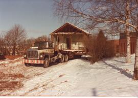 Photograph of the moving of a house off of the NSAC campus near the MacRae Library