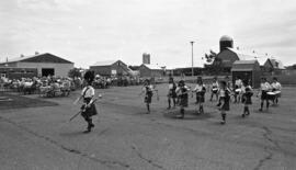 Photographic negative of pipe and drum band marching in a parking lot at the Nova Scotia Agricult...