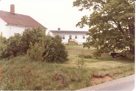 Photograph of what is likely a house and other building through trees during the Sheep Breeders' ...