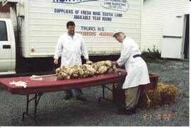 Photograph of Mike Isenor and Doug White carving the roast lamb