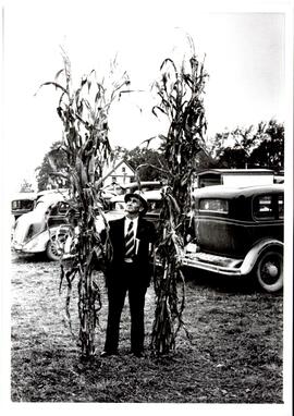 Photograph of a Nova Scotia Agricultural College representative holding up corn for the corn comp...